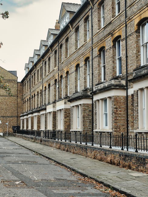 The image depicts a row of traditional brick residential buildings in Fulham with multiple-story facades featuring large sash windows and stone lintels. The buildings are constructed with yellowish-br