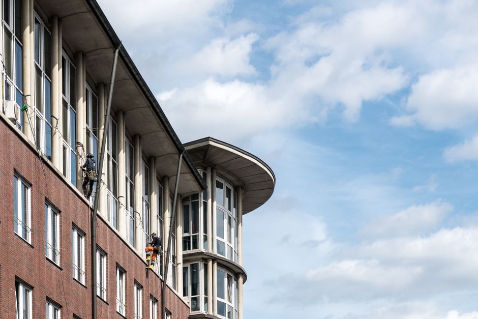 The image depicts a row of traditional brick residential buildings in Fulham with multiple-story facades featuring large sash windows and stone lintels. The buildings are constructed with yellowish-br